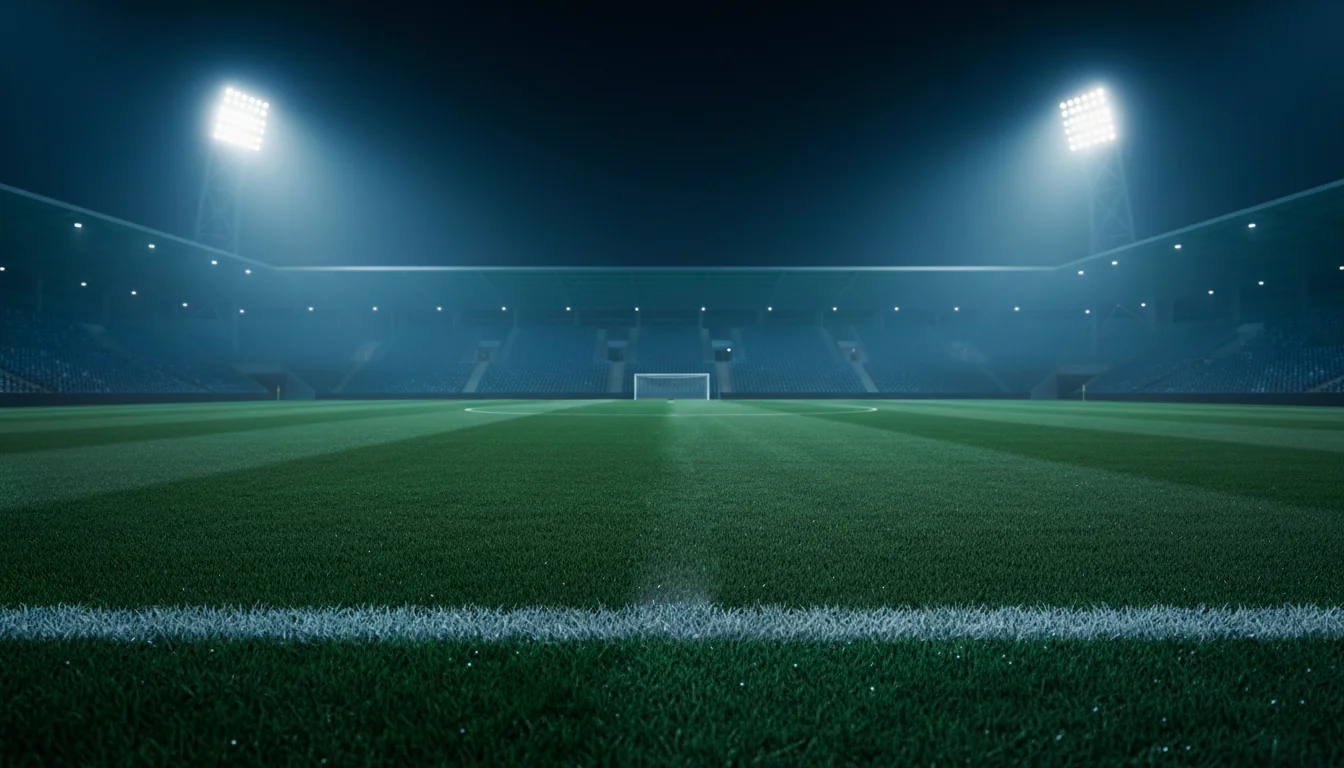 Campo da calcio illuminato di notte con cerchio di centrocampo e riflettori dello stadio