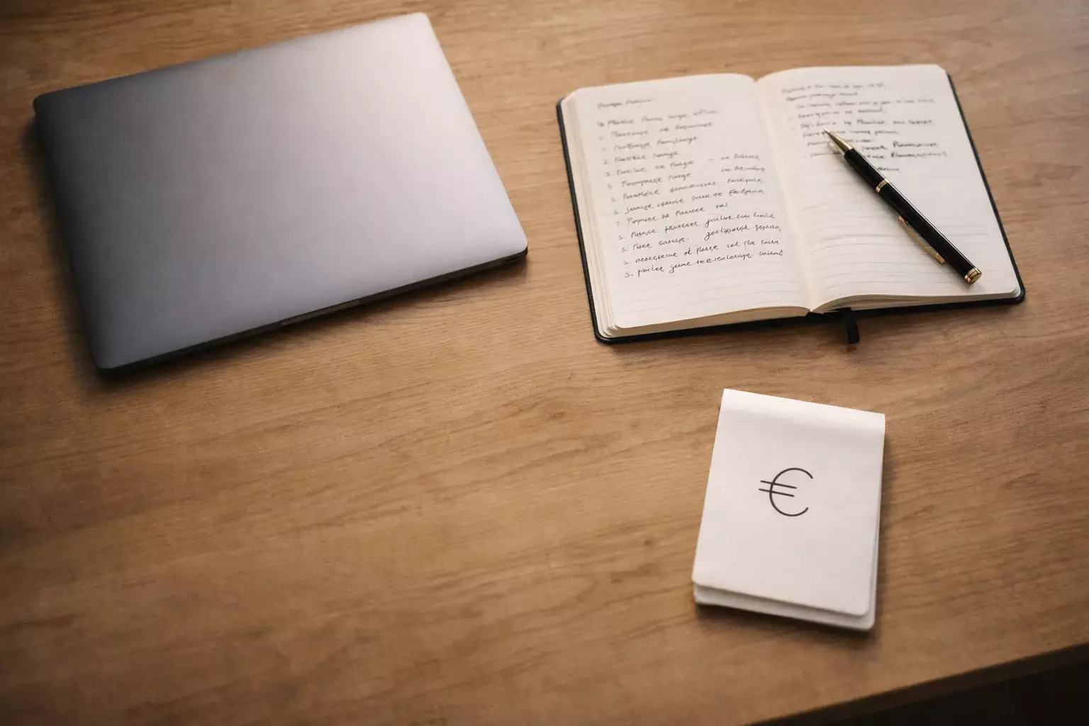 Scrivania organizzata con notebook e appunti per la gestione del budget