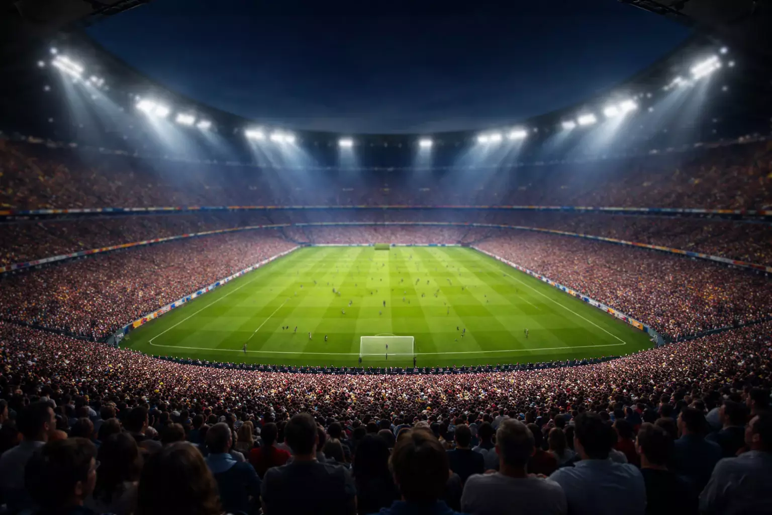 Panoramica di uno stadio di calcio pieno di tifosi durante una partita serale